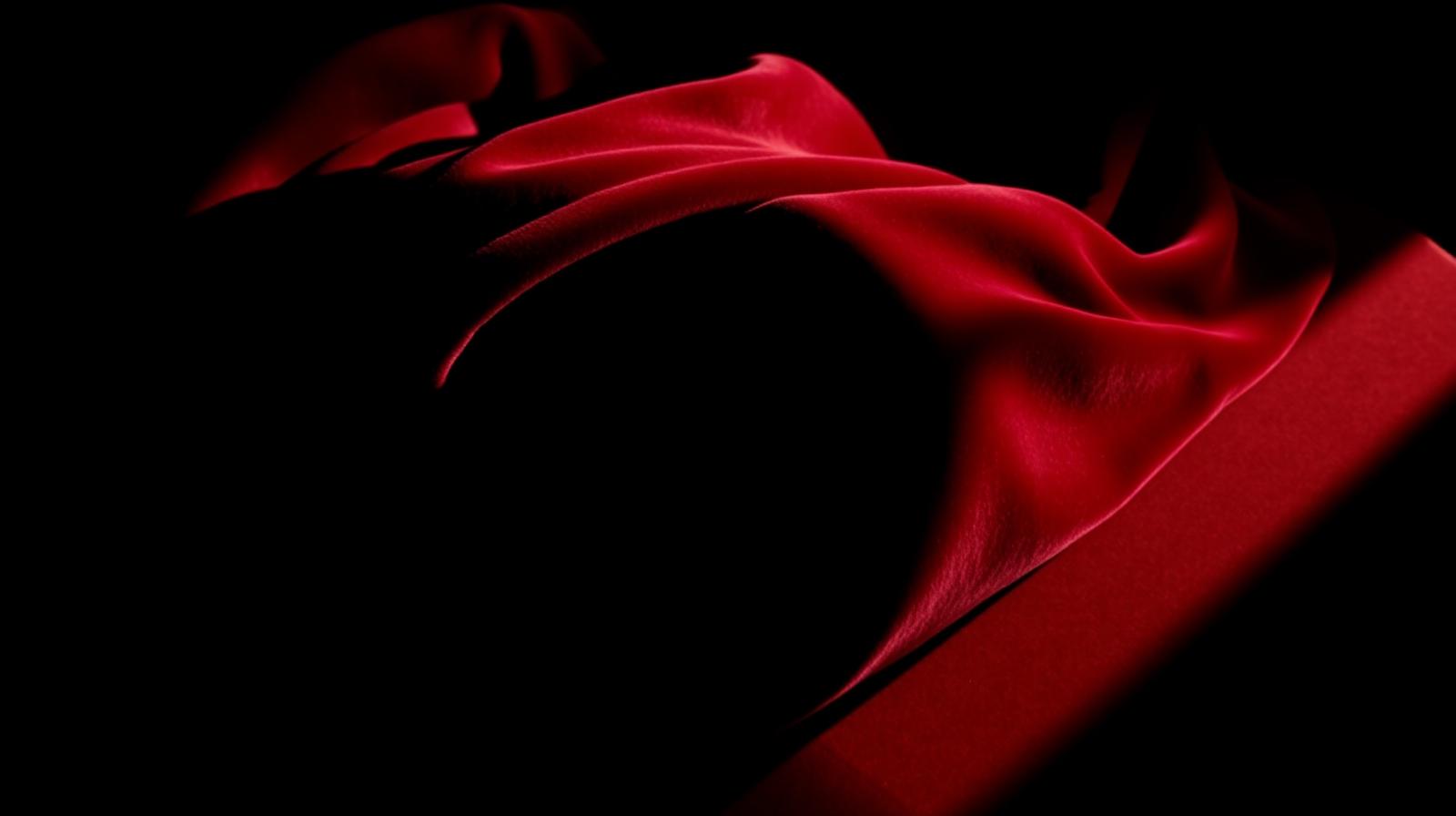 Sculptural folds of oxblood velvet in chiaroscuro